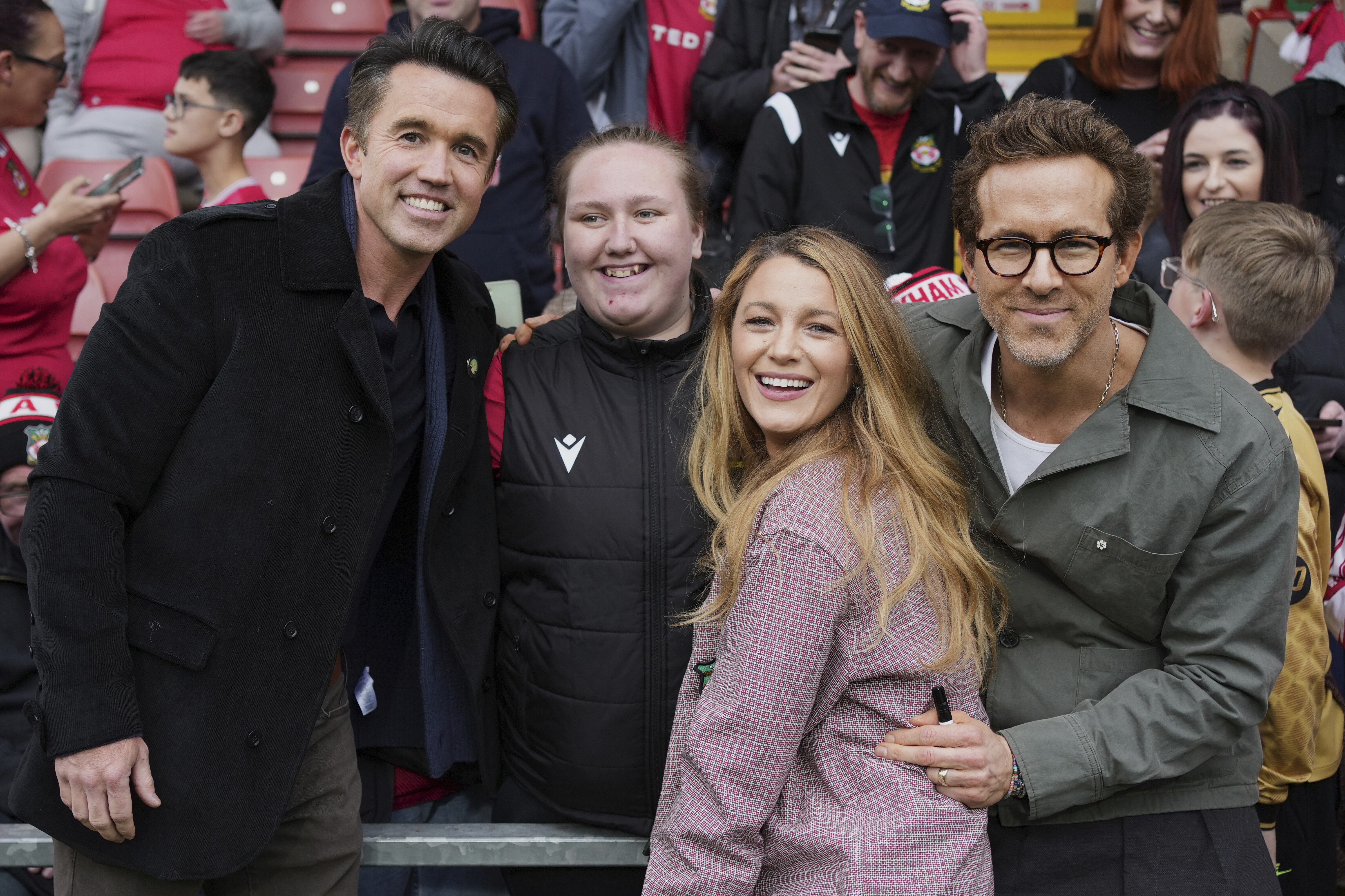 Wrexham co-owners Ryan Reynolds (from right), his wife Blake Lively and Rob McElhenney pose with fans before the English League One soccer match between Wrexham and Charlton Athletic at the Racecourse ground in Wrexham, Wales, on April 26, 2025.